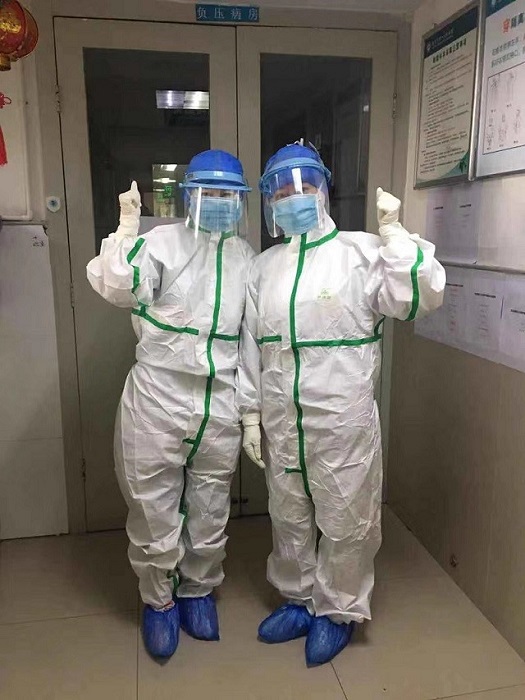 杨莹穿防护服在院感染区门口与同事合影.jpg